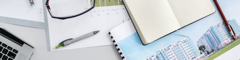 Maps, notebook, ruler and pens lie on office table